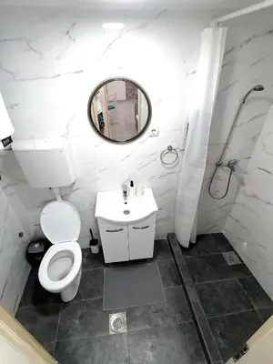 a bathroom with a toilet and a sink and a mirror at Apartman Mata in Soko Banja