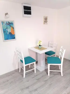 a white table with two chairs and a white table with a table and a table at Apartman Mata in Soko Banja