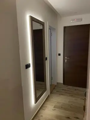 a hallway with a mirror and a door at Apartmani NLUX and SPA in Kopaonik