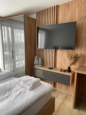 a bedroom with a flat screen tv on a wall at Apartmani NLUX and SPA in Kopaonik