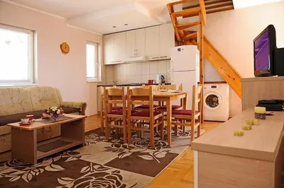 a kitchen and living room with a table and a dining room at Kraljevi čardaci Čar 3 in Kopaonik