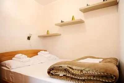 a bedroom with a bed with towels on it at Kraljevi čardaci Čar 3 in Kopaonik