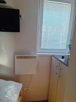 a room with a bed and a window with a air conditioner at Kraljevi čardaci Čar 3 in Kopaonik