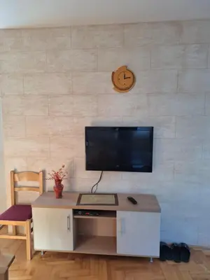a desk with a computer and a clock on a wall at Kraljevi čardaci Čar 3 in Kopaonik
