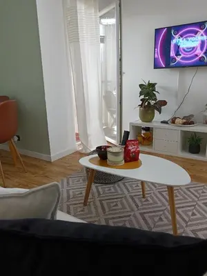 a living room with a coffee table and a tv at Apartman Element in Kruševac