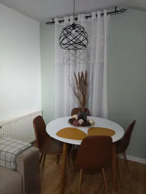 a dining room with a white table and chairs at Apartman Element in Kruševac