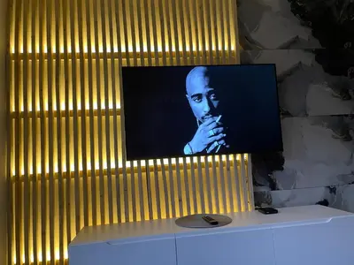 a television with a picture of a man on a wall at Apartman Afrodita Lux 1 in Niš
