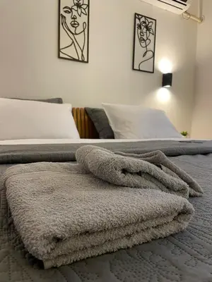 a bed with a pile of towels on it at Apartman Afrodita Lux 1 in Niš