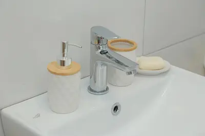 a bathroom sink with a faucet and a toilet at Vila Harmony in Pirot