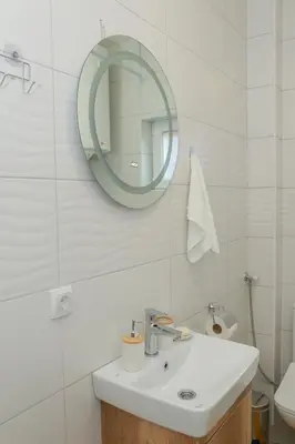 a white bathroom with a sink and a mirror at Vila Harmony in Pirot
