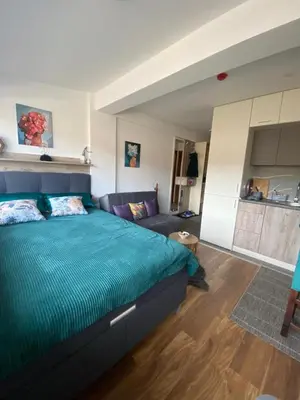a bedroom with a blue bed and a couch at President Kop Apartman A843 in Kopaonik