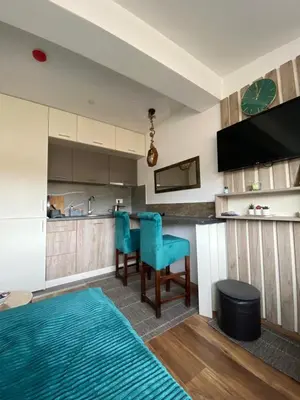 a kitchen with two blue chairs and a kitchen counter at President Kop Apartman A843 in Kopaonik