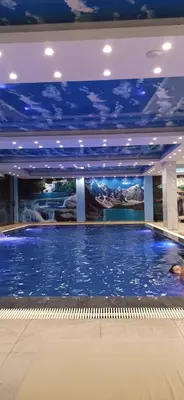 a large swimming pool in a building with a blue ceiling at President Kop Apartman A843 in Kopaonik
