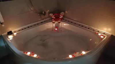 a person standing in a bath tub with christmas lights at Apartman Raj in Vrnjačka Banja