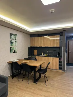 a kitchen and dining room with a wooden table and chairs at Suncana Planina Glory-Kop in Kopaonik