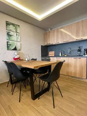 a kitchen with a wooden table and black chairs at Suncana Planina Glory-Kop in Kopaonik