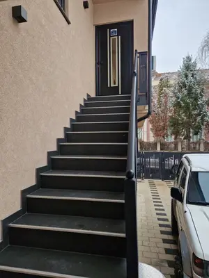a stairway leading up to a house with a black door at Apartman Paradiso in Pirot