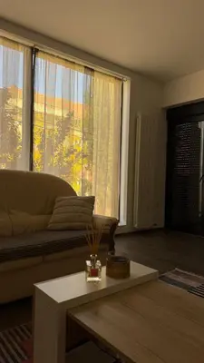 a living room with a couch and a large window at Apartman Paradiso in Pirot