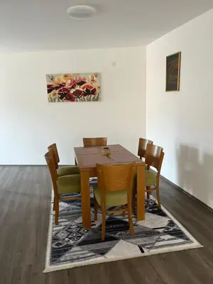 a dining room with a wooden table and chairs at Apartman Paradiso in Pirot