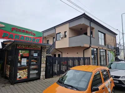 an orange car parked in front of a building at Apartman Paradiso in Pirot
