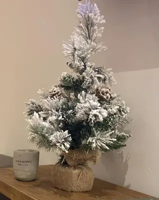 a christmas tree sitting on a table next to a mug at Apartman Jelka Brzece in Brzeće