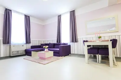 a living room with purple furniture and a table at Vila Palas in Vrnjačka Banja