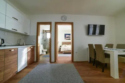 a kitchen and dining room with a table and chairs at Apartman La Foresta Kopaonik in Kopaonik