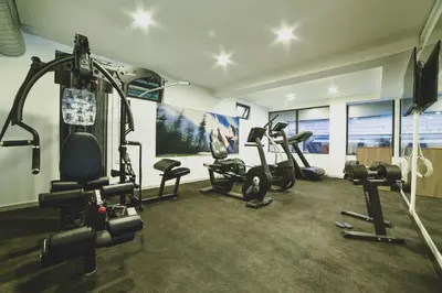 a gym with several treadmills and machines in a room at Apartman La Foresta Kopaonik in Kopaonik