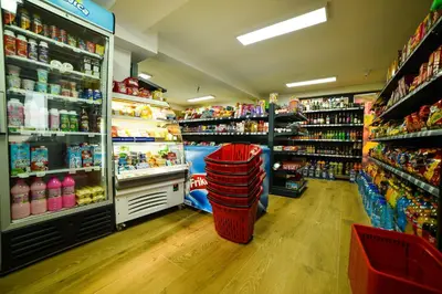 a grocery store aisle with a red trash can in a store at Apartman La Foresta Kopaonik in Kopaonik