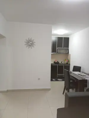 a living room with a table and a kitchen at Apartman Romantic in Vrnjačka Banja