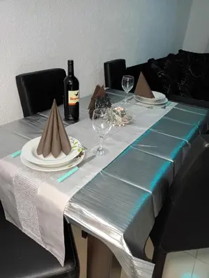 a table with a blue and white table cloth and a bottle of wine at Apartman Romantic in Vrnjačka Banja