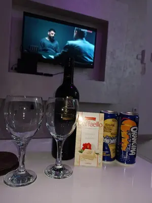 a bottle of wine and two glasses on a table at Apartman Romantic in Vrnjačka Banja