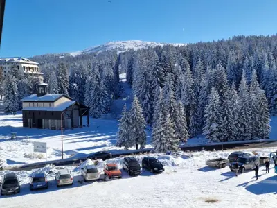 a group of cars parked in a parking lot in the snow at CentralKop in Kopaonik