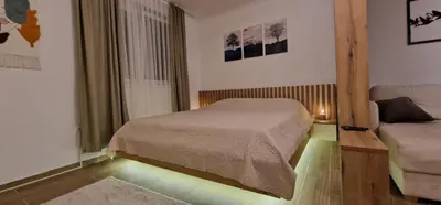 a small bedroom with a bed and a couch at CentralKop in Kopaonik