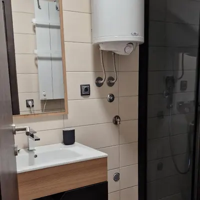 a bathroom with a sink and a mirror and a shower at CentralKop in Kopaonik