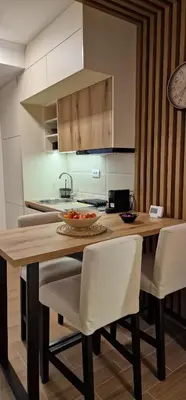 a kitchen with a wooden table and white chairs at CentralKop in Kopaonik