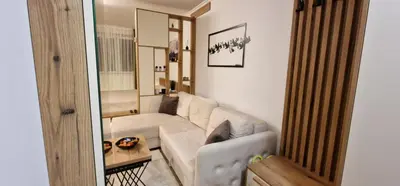 a living room with a white couch and a table at CentralKop in Kopaonik