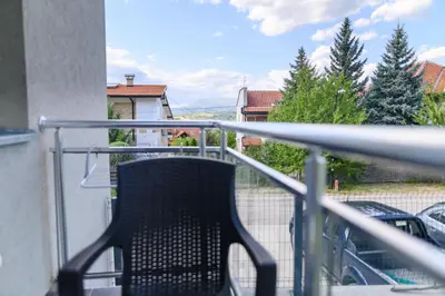 a balcony with a chair sitting on a railing at Apartman MASTER in Soko Banja