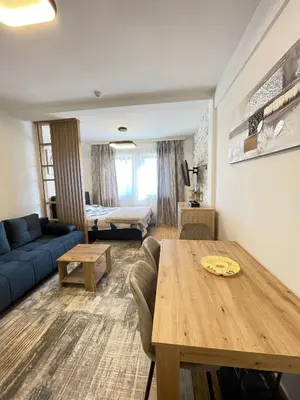 a living room with a blue couch and a table at Geregs alibi in Kopaonik