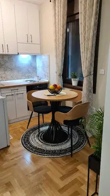 a kitchen with a table with a bowl of fruit on it at MS Apartman in Vrnjačka Banja