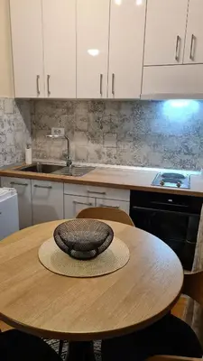 a kitchen with a wooden table with a hat on it at MS Apartman in Vrnjačka Banja