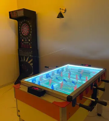 a large shuffleboard table in a room with a clock at Gencian resort in Kopaonik