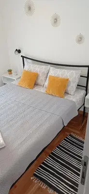 a bed with two orange pillows on top of it at Apartman Vule in Vrnjci