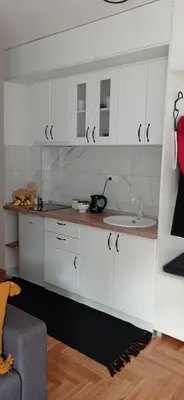 a kitchen with white cabinets and a sink at Apartman Vule in Vrnjci