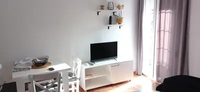 a living room with a white table with a television on it at Apartman Vule in Vrnjci