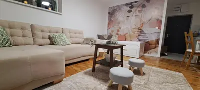 a living room with a couch and a table and stools at A2Kopaonik newly built apartments in Kopaonik