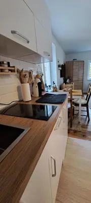 a kitchen with white cabinets and a dining room at A2Kopaonik newly built apartments in Kopaonik