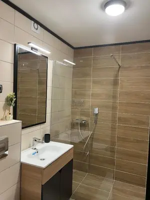 a bathroom with a shower with a sink and a shower at Apartman BM403 in Kopaonik
