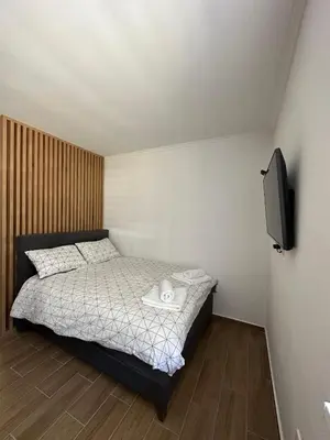 a small bedroom with a bed and a television at Apartman BM403 in Kopaonik