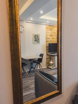 a mirror in a room with a table and a chair at Milmari Premier - Daisy Apartments in Kopaonik